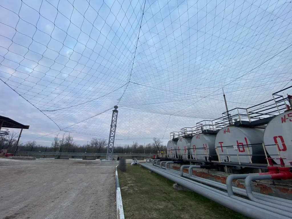 Панорама: защитная сетка на опорах над резервуарами нефтебазы